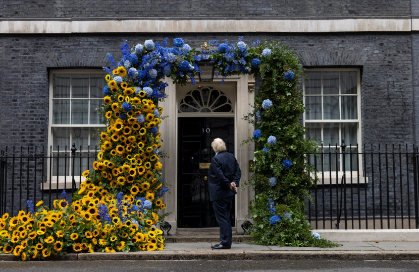 UK Prime Minister outside 10 Downing Street with archway of flowers in national colours of Ukraine to mark Ukraine's 31st Independence Day